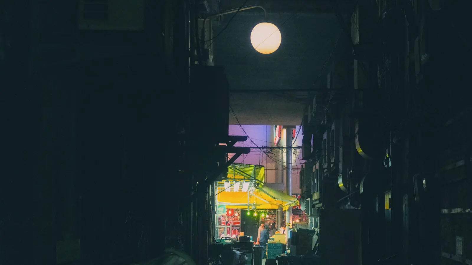 暗い路地の上に、丸い外灯がひとつだけ灯っている夜