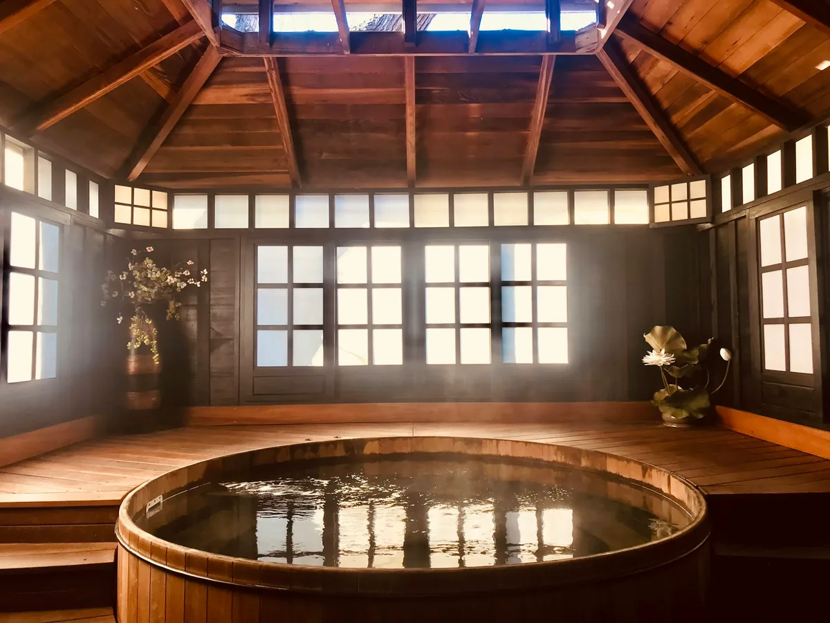 円い木の浴槽から立ちのぼる湯気と、木組みの天井